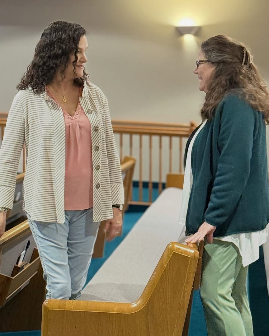 Two women talking in the pews before the service